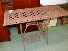 A VINTAGE CAST IRON GARDEN TABLE FORMED FROM A SINGER SEWING MACHINE BASE WITH A VICTORIAN PIERCED