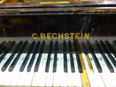 AN ANTIQUE BECHSTEIN EBONISED GRAND PIANO ON SQUARE TAPERED LEGS WITH IRON WHEELD BRACE,