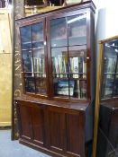 AN ANTIQUE GEORGIAN STYLE MAHOGANY BOOKCASE WITH TWIN GLAZED DOORS OVER PANEL DOOR ENCLOSED CUPBOARD