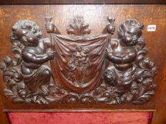 AN ANTIQUE OAK FIRE SUPPOUND, RE MADE INCORPORATING CARVED OAK CENTRAL DECORATION OF PUTTI