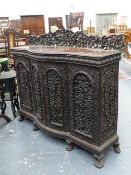 AN IMPRESSIVE ANTIQUE BURMESE HARDWOOD SIDE CABINET WITH CARVED CREST OVER FOUR CARVED AND PIERCED