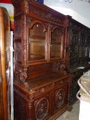 AN ANTIQUE FRENCH CARVED OAK BOOKCASE CABINET WITH GLAZED UPPER OVER TWO DRAWERS AND TWO DOORS