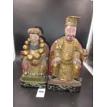 A PAIR OF CHINESE LACQUERED WOOD FIGURES OF AN EMPEROR AND EMPRESS SEATED ON RED THRONES DRAPED WITH