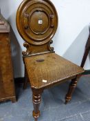 A PAIR OF 19th.C.OAK HALL CHAIRS WITH ROUND CARTOUCHE PANEL BACKS ON TURNED FORELEGS. (2)