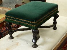 AN EARLY CARVED AND EBONISED STOOL WITH SCROLL LEGS AND CROSS STRETCHER.