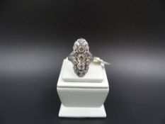 A DIAMOND SET ELONGATED RING, STAMPED 750 AND TESTED AS 18ct GOLD. THE THREE CENTRAL DIAMONDS ARE