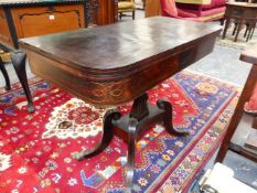 A REGENCY ROSEWOOD AND BOXWOOD STRUNG FOLD OVER CARD TABLE ON SHAPED SQUARE COLUMN AND SABRE LEGS.
