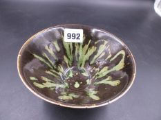 A CHINESE TRUNCATED CONICAL BOWL, THE TREACLE BLACK GLAZED SPLASHED AND STREAKED IN GREEN. Dia.14.