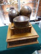 THREE ANTIQUE WOODEN TREEN HAT BLOCKS.AND A VICTORIAN CARVED OAK DISPLAY PLINTH. (4)