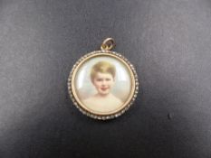 A PAINTED WATERCOLOUR MINIATURE OF A YOUNG BOY CONTAINED IN A VICTORIAN OPEN FACE LOCKET SET WITH