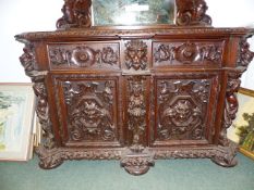 A HIGHLY CARVED WALNUT BAROQUE STYLE CABINET DECORATED WITH ELABORATE FIGURAL AND FOLIATE MOTIFS