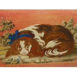 A BERLIN WOOLWORK PICTURE OF A RECLINING KING CHARLES SPANIEL WEARING A BLUE SASH COLLAR WITHIN GILT