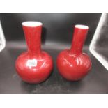 TWO CHINESE SANG DE BOEUF BOTTLE VASES, ONE WITH THE WIDER DIAMETER NECK WITH A MOTTLED RED GLAZE.