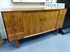 A GORDON RUSSELL TEAK AND ROSEWOOD SIDEBOARD WITH A PAIR OF CENTRAL DOORS FLANKED BY EIGHT SHORT