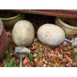 A PAIR OF EGG FORM STONE GATEPOST FINIALS.