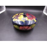 A MOORCROFT HIBISCUS PATTERN ROYAL BLUE GROUND COVERED BOWL.