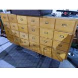 A VINTAGE HABERDASHERY COUNTER WITH A BANK OF TWENTY FOUR DRAWERS AND DISPLAY SHELVES OPPOSITE. L.