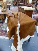 TAXIDERMY. A LARGE BROWN AND WHITE COW HIDE.