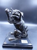 AN ORIENTAL BRONZE FIGURE OF A SEATED FOO LION WITH UPRAISED PAWS. H.17cms.