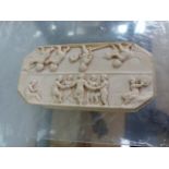 AN IVORY BOX LID CARVED WITH NAKED FIGURES.