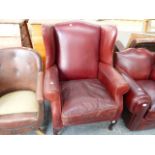 A LEATHER WING BACK ARMCHAIR.