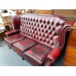 A BUTTON UPHOLSTERED WING BACK SETTEE.