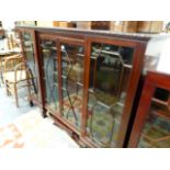 AN EDWARDIAN MAHOGANY INVERTED BREAKFRONT GLAZED BOOKCASE.