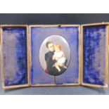 A LEATHER CASED OVAL PORCELAIN PLAQUE PAINTED WITH A SEATED MOTHER HOLDING HER CHILD ON HER LAP, THE