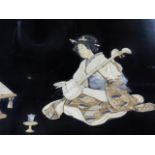 A JAPANESE BLACK LACQUER PLAQUE INLAID WITH A LADY SEATED BEFORE A LECTERN PLAYING A SAMISEN. 36 X