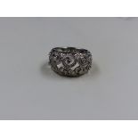 AN 18CT WHITE GOLD DIAMOND RING WITH A FILIGREE SWIRL DESIGN, COLOUR G/H, CLARITY SI1, APPROX