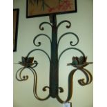 A SET OF FOUR WEATHERED WROUGHT IRON TWIN LIGHT WALL SCONCES WITH SCROLL WORK BACK PLATES AND