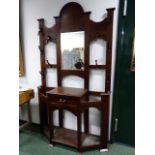 AN OAK ARTS AND CRAFTS MIRROR BACK HAT / STICKSTAND WITH SHAPED CREST ABOVE BEVELLED PLATE AND