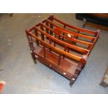 A MAHOGANY CANTERBURY WITH FOUR DIVISIONS AND CENTRAL PIERCED HANDHOLD ON RING TURNED TAPERED LEGS