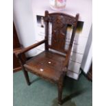 AN INTERESTING CARVED OAK RUSTIC ARMCHAIR, THE BACK DECORATED WITH A MAN'S PROFILE PORTRAIT. THE