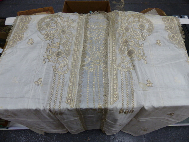 AN ALBANIAN WHITE SILK WEDDING DRESS WORKED WITH FLOWERS IN SILVER THREAD LACEWORK AND PALE