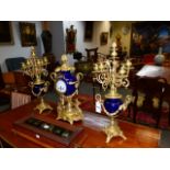 AN ORMOLU MOUNTED FRENCH THREE PIECE CLOCK GARNITURE IN THE LOUIS XVI TASTE, THE TWIN HANDLED