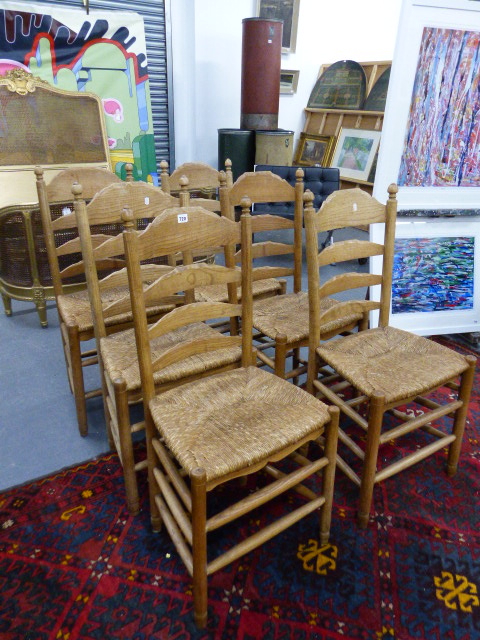 A SET OF SIX ASH RUSH SEATED LADDER BACK CHAIRS.