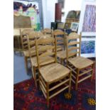 A SET OF SIX ASH RUSH SEATED LADDER BACK CHAIRS.