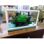 A SCRATCH BUILT LIVE STEAM 0-4-0 LOCOMOTIVE DISPLAYED IN GLAZED CASE.