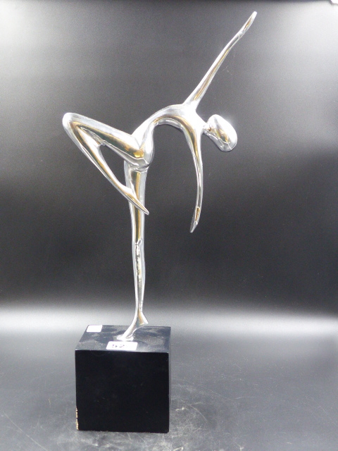 A METAL FIGURE OF AN ART DECO DANCER POSED ON ONE FOOT ON AN EBONISED PLINTH. H.44.5CMS.