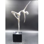 A METAL FIGURE OF AN ART DECO DANCER POSED ON ONE FOOT ON AN EBONISED PLINTH. H.44.5CMS.