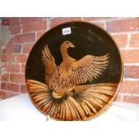 A LATE 1970'S POOLE DISH DECORATED BY DIANA FOREMAN WITH A BIRD TAKING FLIGHT. DIA.34CMS.