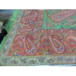 AN INDIAN GREEN GROUND WOOL SHAWL EMBROIDERED WITH STYLISED BUDS, FLOWERS AND FOLIAGE TOGETHER