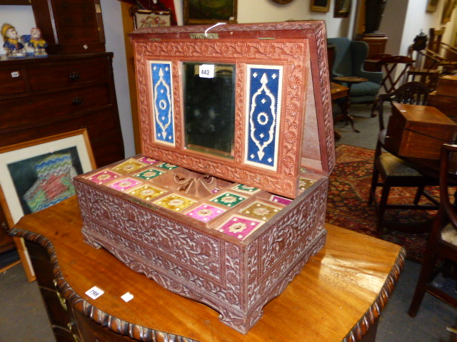 AN ANGLO INDIAN ELABORATELY CARVED HARDWOOD WORK BOX WITH LIFT TOP AND MIRROR BACK ENCLOSING