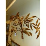 A GILT METAL DECORATIVE APPLIQUE IN THE FORM OF A TIED SPRAY OF LEAFY BRANCHES.W.130 X H.90CMS.