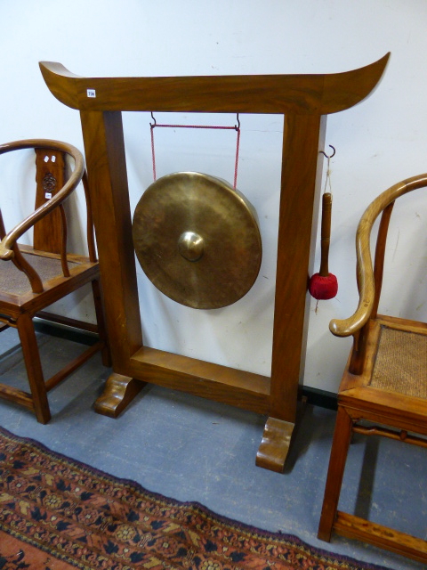 A LARGE HARDWOOD FRAMED GONG ON STAND. W.110 X H.130CMS. GONG DIA.50CMS.