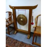 A LARGE HARDWOOD FRAMED GONG ON STAND. W.110 X H.130CMS. GONG DIA.50CMS.