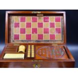 A VINTAGE MAHOGANY GAMES COMPENDIUM CONTAINING WOODEN CHESS AND DRAUGHTSMEN, BONE DOMINOES, GLASS