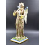 A MAJOLICA FIGURE OF AN ANGEL PLAYING A VIOLIN, THE LONG PINK ROBE PAINTED WITH GREEN OLIVE