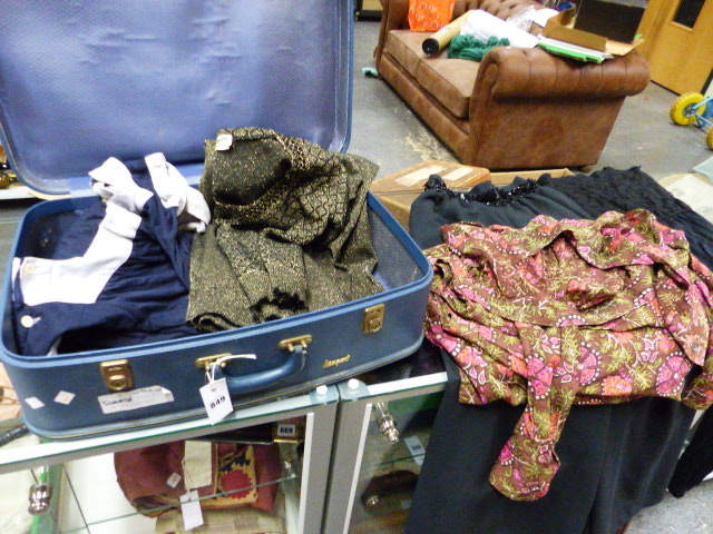 A GINA BACCONI LABELLED BLACK CULOTTES TOGETHER WITH OTHER LABELLED CLOTHING IN A SUITCASE.
